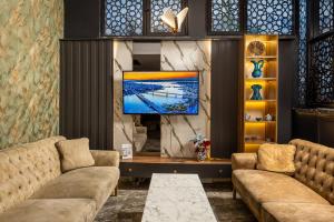 a living room with two couches and a flat screen tv at Sultanahmet Nu Hotel in Istanbul