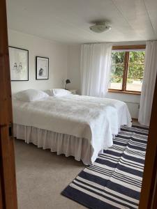 a bedroom with a large white bed and a window at Valhallsvägen 45 in Ängelholm