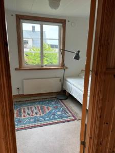 a room with a bed and a window and a rug at Valhallsvägen 45 in Ängelholm