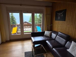 a living room with a black leather couch and chairs at Residence Edelweiss No Stress by Eva in Bellwald