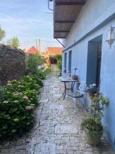 a stone walkway with a table and chairs on a building at Apartman Modrý dom in Levoča