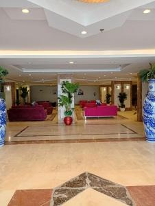 a lobby with couches and plants in a building at شقق ليالي الشاطئ in Al Qunfudhah