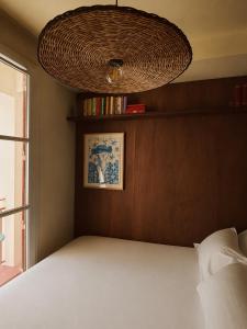 a bedroom with a bed with a large ceiling at Hôtel Le Voltaire in Arles