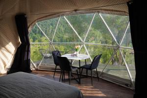 a room with a table and chairs and a large window at Kamp Glamp Plivska Oaza in Jajce