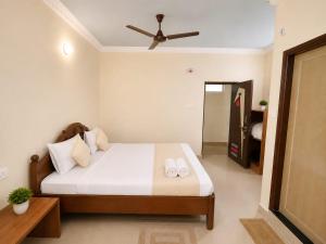 a bedroom with a bed and a ceiling fan at Hotel Oceano in Puri