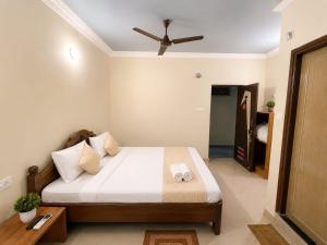 a bedroom with a bed and a ceiling fan at Hotel Oceano in Puri