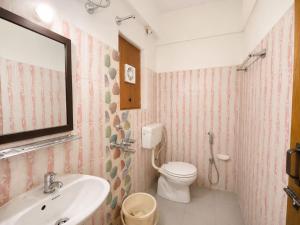 a bathroom with a sink and a toilet and a mirror at Hotel Oceano in Puri