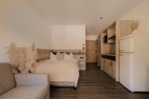 a bedroom with a white bed and a couch at Rössl Lodge in Gerlos