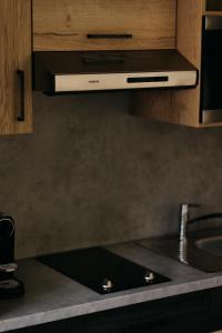 a kitchen with a stove top with a sink at Rössl Lodge in Gerlos +20 photos
