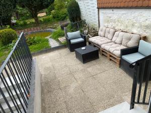 a patio with a couch and two chairs and a table at Chambrette bei Kassel in Eiterhagen