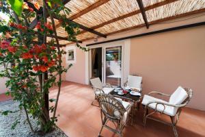 a patio with a table and chairs and a tree at Hotel Fabricia in Portoferraio