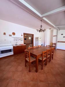 a dining room with a wooden table and chairs at Ciuscia 0 in Calatabiano +9 photos