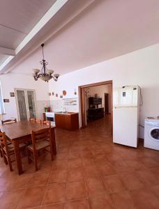 a kitchen and dining room with a table and a refrigerator at Ciuscia 0 in Calatabiano