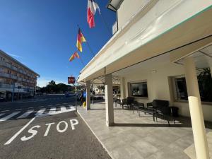 ein Stoppschild vor einem Gebäude mit Flaggen in der Unterkunft Hotel Al Capitano in Caorle