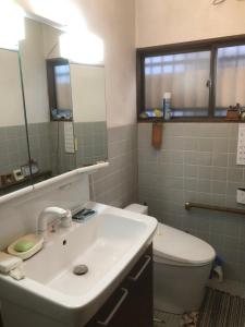 a bathroom with a sink and a toilet and a mirror at スペースigusa専用寝室2室に2名様3泊よりマンスリー割引がおすすめ in Tokyo