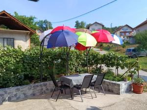 a table and chairs with umbrellas in a yard at Kuća - Šekovići in Šekovići