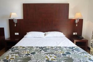 a bed with a wooden head board and two night stands at Capo D'orto - Porto - Corse in Porto Ota