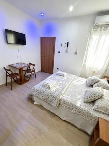 a bedroom with a large bed and a table at Il Faro Suites in Taranto