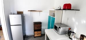 a kitchen with two refrigerators and a table with a microwave at Joe's Place Self-Catering in Windhoek +2 photos
