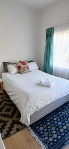 a bed with white sheets and pillows in a bedroom at Joe's Place Self-Catering in Windhoek