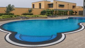 a swimming pool in front of a building at Rosastays Kutch in Tuna