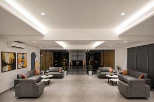 a waiting room with couches and tables in a building at Rosastays Kutch in Tuna