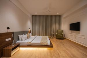 a hotel room with a bed and a television at Rosastays Kutch in Tuna +7 photos