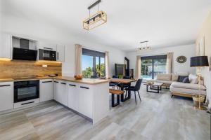 a kitchen with white cabinets and a living room at Villa Theofilos in Glossa +29 photos