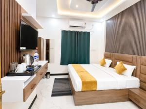 a hotel room with a bed and a television at Hotel Royal Awadh Near Shree Ram Mandir Ayodhya in Ayodhya