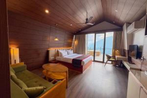 a hotel room with a bed and a couch at Hamta 270 Cliff Resort - 270 Degree Mountain View Suites, Sethan Manali in Manāli