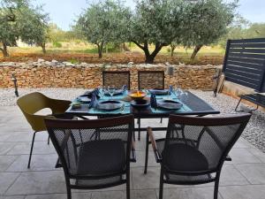 a black table and chairs on a patio at Apartman Rebecca in Peroj