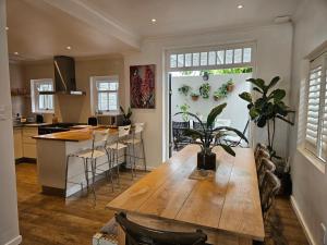 a kitchen with a wooden table and a dining room at Cherry Tree House, Newlands in Cape Town