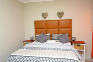 a bedroom with a large bed with two hearts on the wall at TALITHA'S SELF-CATERING ACCOMMODATION in Walvis Bay