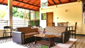 a living room with couches and a table and a table at Nature View Villa in Badulla
