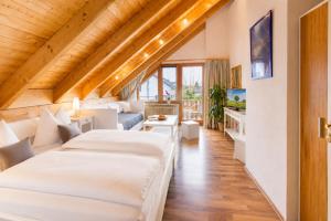a hotel room with two beds and a couch at Haus Rose in Allensbach