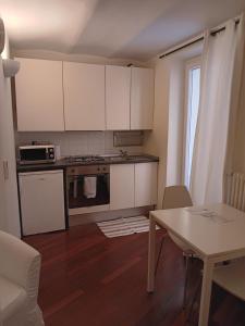 a small kitchen with white cabinets and a table at Splendido Bilocale in Savona +11 photos