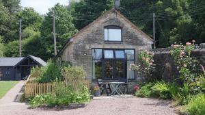 a small stone cottage with a window at Horse Gin in Lydney