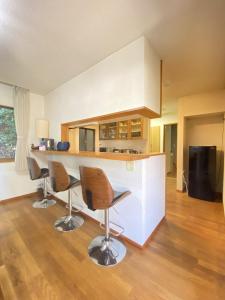 a kitchen with a counter and chairs in a room at トラストメゾン西伊豆 in Ukusu
