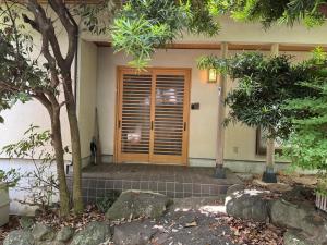 a house with a wooden door with a window at トラストメゾン西伊豆 in Ukusu