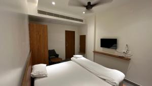 a bedroom with a bed and a tv on the wall at Kosala grand in Bhadrāchalam