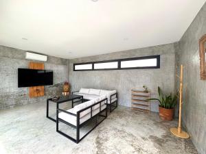a living room with a couch and a tv at Big leaf villa kohsamui in Bangrak Beach