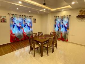 a dining room with a wooden table and chairs at Tropical Haven in Panaji