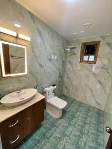 a bathroom with a white toilet and a sink at Tropical Haven in Panaji
