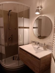 a bathroom with a sink and a shower with a mirror at Splendido Bilocale in Savona
