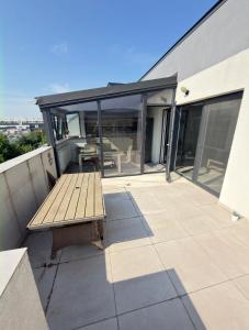 a patio with a wooden bench on top of a building at Cajara Home in Bucharest