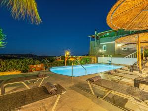 a swimming pool with two chairs and a building at Holiday Sea View Villas in Katastárion +44 photos