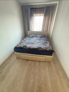 a small bed in a room with a window at Cajara Home in Bucharest