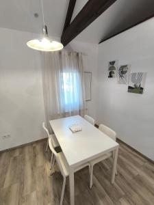 a dining room with a white table and chairs at Casa Fontenlos in Tui