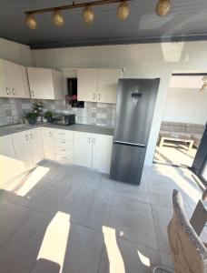 a kitchen with white cabinets and a stainless steel refrigerator at Cajara Home in Bucharest