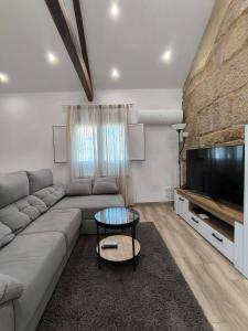 a living room with a couch and a flat screen tv at Casa Fontenlos in Tui